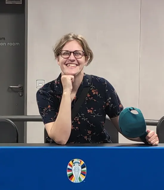 The author, Erika, is pictured at a European football league post-game interview desk